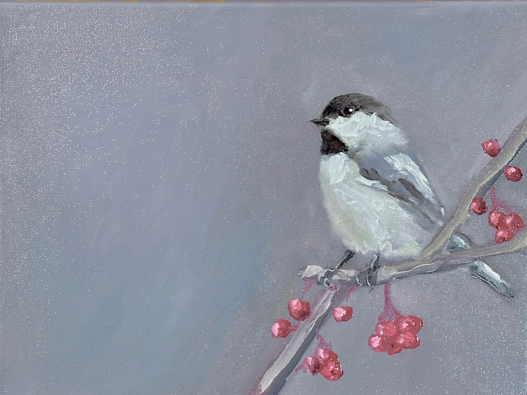 A small bird positioned on the right side of a quiet grey field, with open space extending to the right.